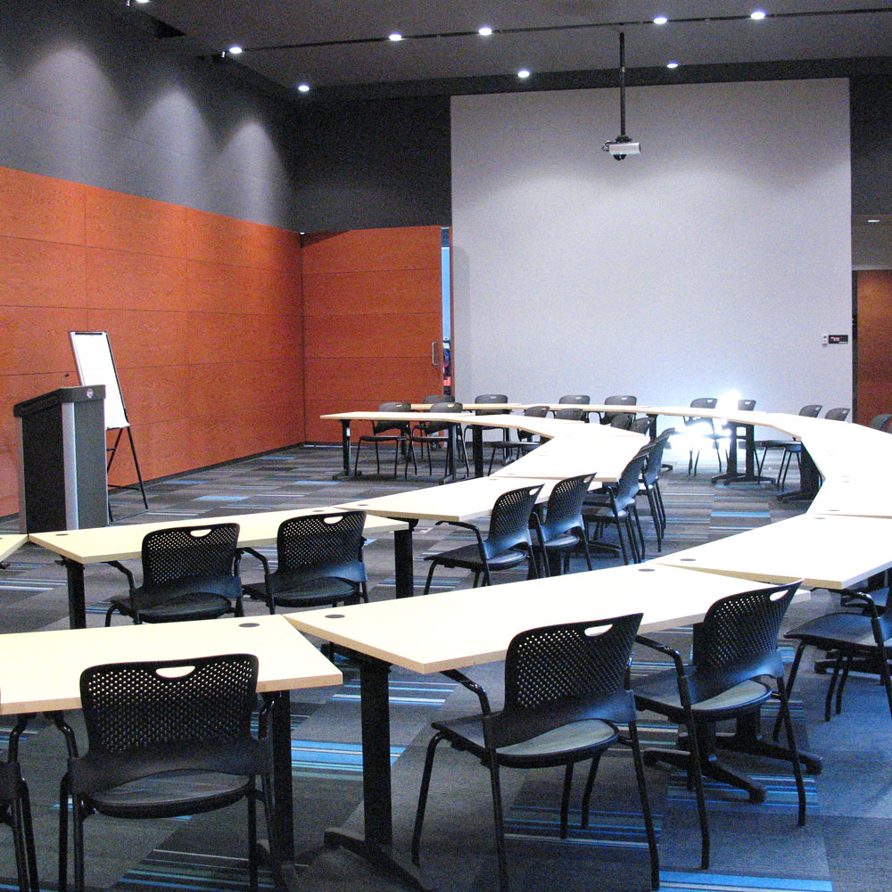 meeting room with podium, tables, chairs in semi circle