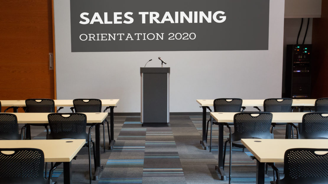 event venue and meeting space showing square tables and chairs with water pitchers, set for sales training