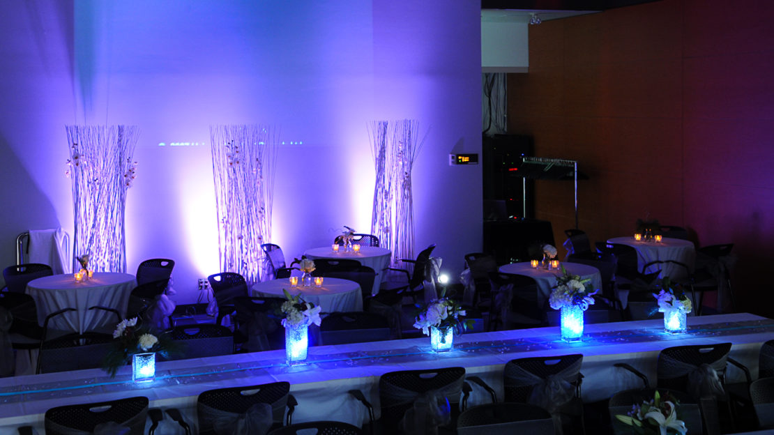 event venue and meeting space showing square tables and chairs set for dining.