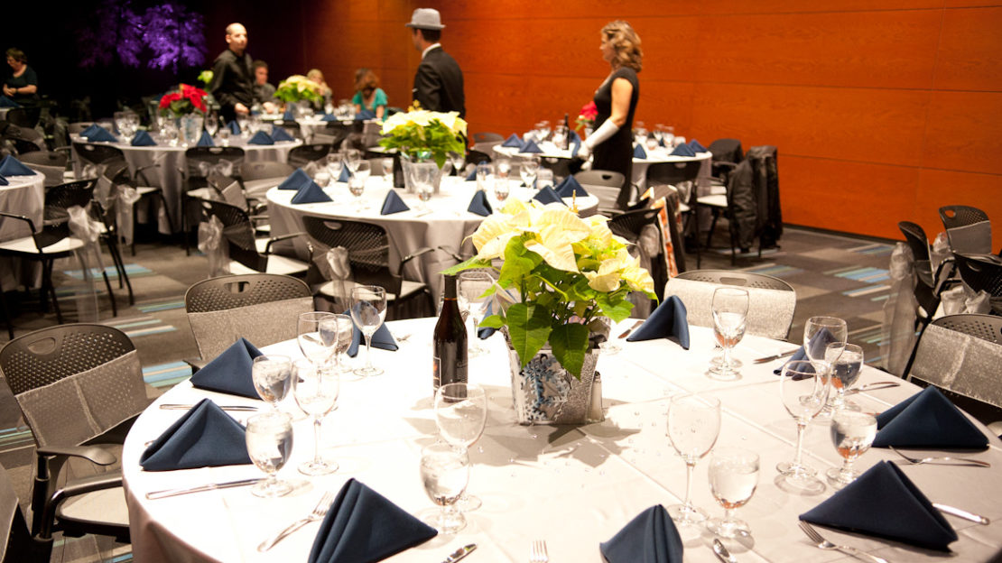 event venue and meeting space showing square tables and chairs set for dining.